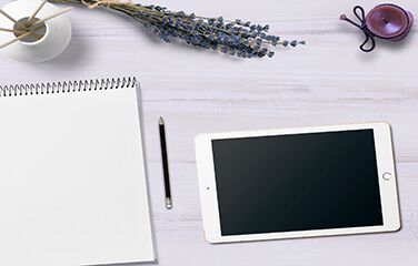 Draufsicht auf iPad und Notizblock mit Bleistift