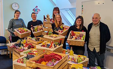 Fünf Mitarbeitende von Lünestrom und Jürgen Kalinke vom Förderverein "Kinder in Wittorf" stehen hinter einem Tisch mit zahlreichen Präsentkörben.